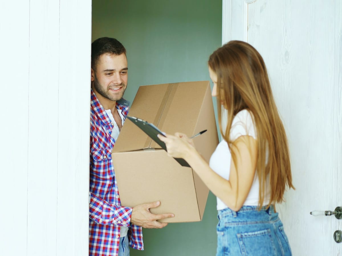 Courier handing a parcel to a customer at the front door