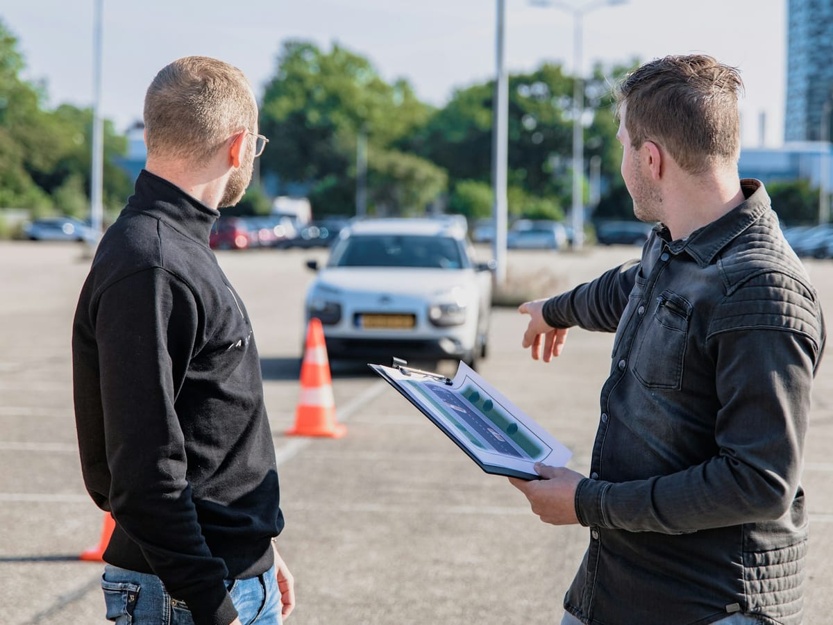 Driving instructor with a clipboard explaining the practice course to a learner